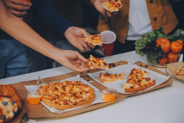 Group of young friends eating pizza.Home party.
