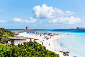 Obraz premium An elevated view reveals the vibrant life of La Pelosa beach, where people dot the shore, blending with the brilliant blue waters of the bay.