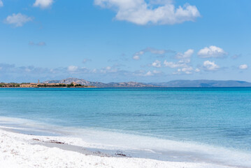 Le Saline beach landscape: turquoise sea meets a distant horizon with faint landforms, under a vast...
