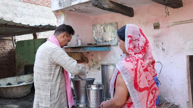 Happy Indian man selling cow milk to customer at his farm, Concept of dairy farming industry business. Rural india.
