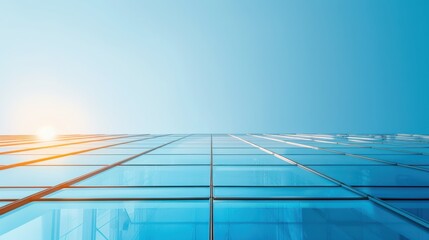 Reflective Glass Facade, a striking view of a tall buildings glass exterior reaching toward a clear blue sky, illuminated by warm sunlight enhancing its sleek design.