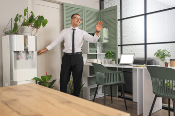 Handsome businessman opening door in office