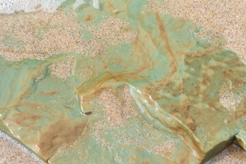 Beach treasure, stone on the beach sand. Close up view. 