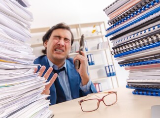 Young handsome businessman unhappy with excessive work