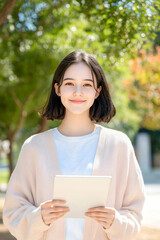 Fototapeta premium Smiling Young Woman Holding Tablet in Modern Bright Interior