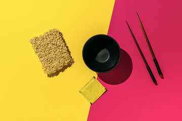 Instant Noodles and Chopsticks on Vibrant Yellow and Pink Background