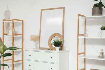 Interior of light living room with commode and shelf units