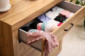 Open drawer with women's underwear in room, closeup