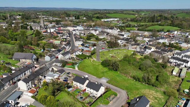 Round Tower, Clones Town, County Monaghan, Ireland, April 2023. Drone orbits the 10th Century monastic structure counter clockwise with the Cassandra Hand Heritage Centre in the background.