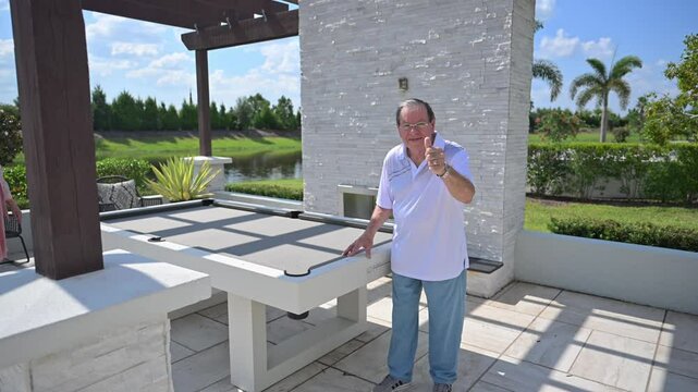 man pleased with his luxury outdoor entertainment deck addition and remodel