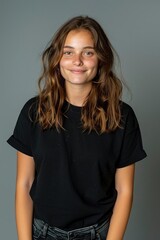 Obraz premium A Happy Young Woman Standing Against A Gray Background, Looking Cheerful