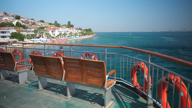 View from the upper deck of the ferry in the Sea of Marmara to the Kinaliada Island in Adalar district of Istanbul with the public beach and many houses on the hill