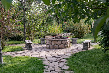 Courtyard with fire pit and benches. Beautiful garden patio design with pergola and fire pit. A place to relax surrounded by lush nature.
