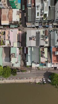 Ho Chi Min City, Vietnam District eight from vertical top down aerial view featuring rooftops, dense urban housing, streets and alleyways. Camera moves from botom to top along alleyway.