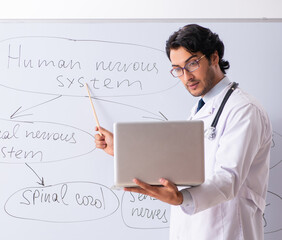 Young male doctor neurologist in front of whiteboard