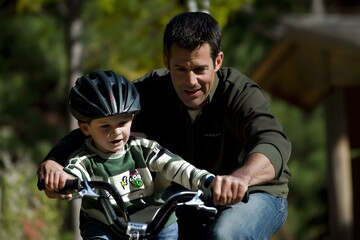 Father Teaching Son To Ride A Bike In The Woods