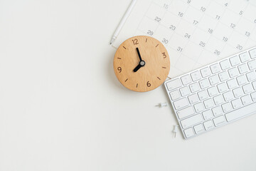 close up of calendar, keyboard and clock on the white table background, planning for business meeting or travel planning concept