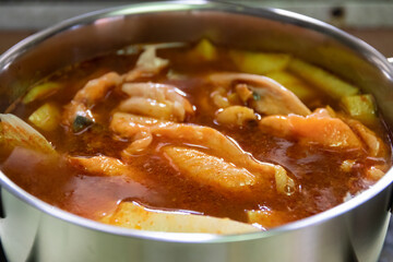 Pot of yellow curry with salmon and bamboo shoot thai southern style food.