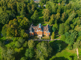 An old castle in the middle in the park. Old manor from drone view