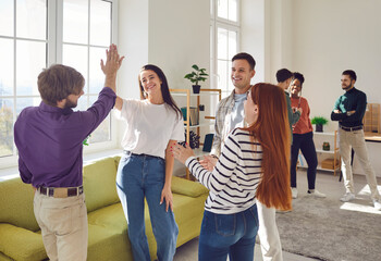 Diverse group of cheerful smiling people friends or coworkers meeting in the living room together,...