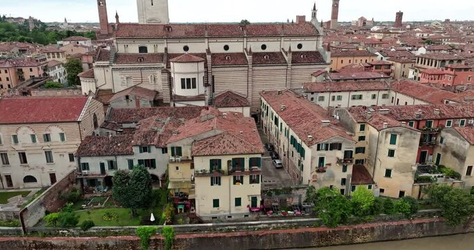 Aerial view of the urban landscape of Verona, Italy. Historical architecture of houses on the river bank with red roofs. High quality 4k footage