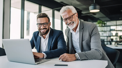 two businessmen working on laptops.
