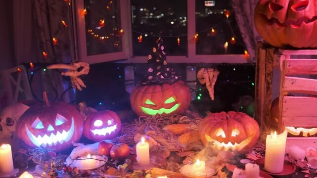 Funny pumpkin dancing with spooky hands decorating the halloween party with flickering fire lights from candles and mist.