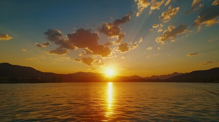 Fototapeta premium Golden Sunset over Lake with Mountain Silhouette