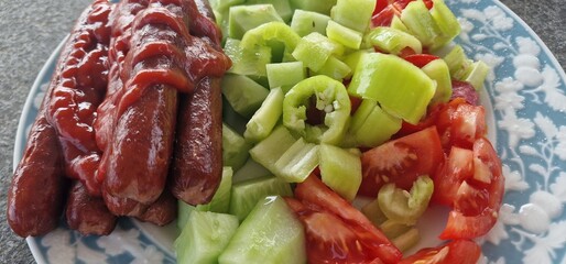 Sausage with salad tomatoes, cucumbers, peppers and tomato ketchup