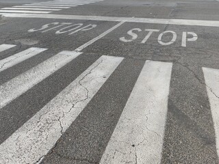 Detail of a crossing with pedestrian crossings and a stop sign for cars.