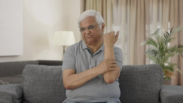 Sick Indian old man suffering from arthritis