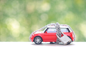 Debt,Locked miniature yellow car model with padlock and chain on natural green background,Vehicle...