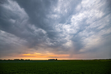 Storm clouds gather over the wide open plains at sunset