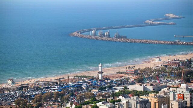 City skyline with a large body of water in the background. Ashdod in Israel. View on the beach and port. The buildings are tall and the city appears to be bustling with activity. High quality 4k