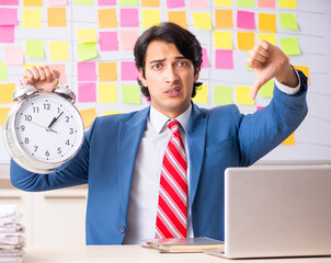 Young handsome employee with many conflicting priorities