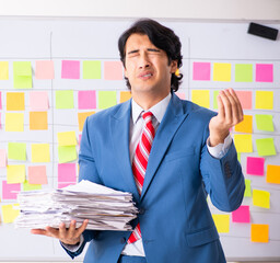 Young handsome employee with many conflicting priorities