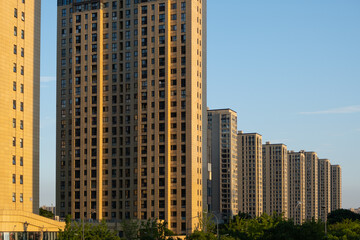 Modern, high-rise residential apartment buildings with a uniform design in a densely populated urban neighborhood in China. Concept of real estate, property investment and housing. © Doublelee