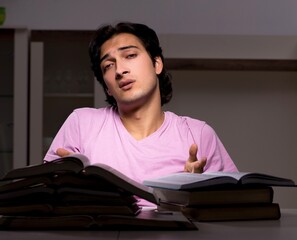 Male handsome student preparing for exams late at home