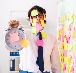 Young employee in conflicting priorities concept
