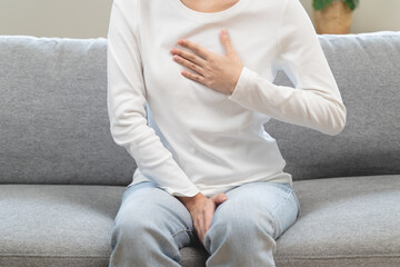 Acid reflux disease, suffer asian young woman have symptom gastroesophageal, esophageal, stomach ache and heartburn pain hand on chest from digestion problem after eat food, Healthcare medical concept