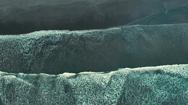 Barrido de olas blancas que crean un efecto de s&aacute;banas en la arena que es captado por un drone en 4k. Este espect&aacute;culo natural se crea desde las alturas y toca la arena amarilla, azul y atardeceres.