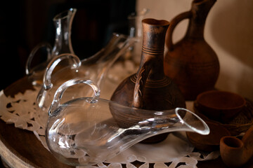 Wine decanter on the table next to a beautiful clay jug. Wine tableware