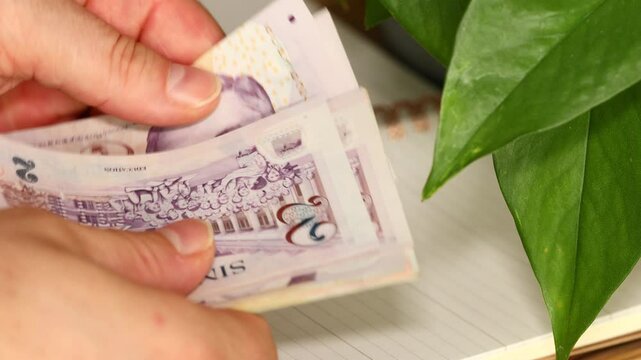 Businessman counting Singapore dollars on business notebook background. Financial concept, Singapore money