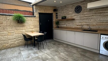 Explore a spacious kitchen with a washing machine, sleek cabinetry, and a cozy dining setup, enhancing modern living in a stylish space.