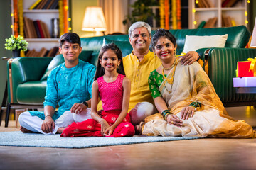 Indian family siutting with gift box on sofa on diwali festival night