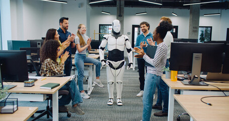 Creators surrounding robot and clapping with their hands. Automated gadget performing moves. Trying...