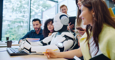 Side view of multi-ethnic group of people gathering around cyborg. Looking with interest as robot...