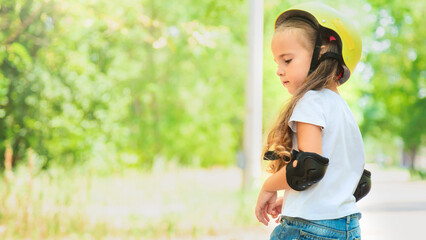 Girl skateboard with safety equipment - helmet, knee and elbow pads. Safe summer activity. Kids activity.