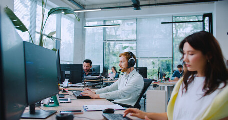 Caucasian male picking up headset with microphone. Talking with client. Supporting people....
