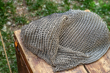 a pile of iron chain mail stacked on a wooden surface, warrior protection